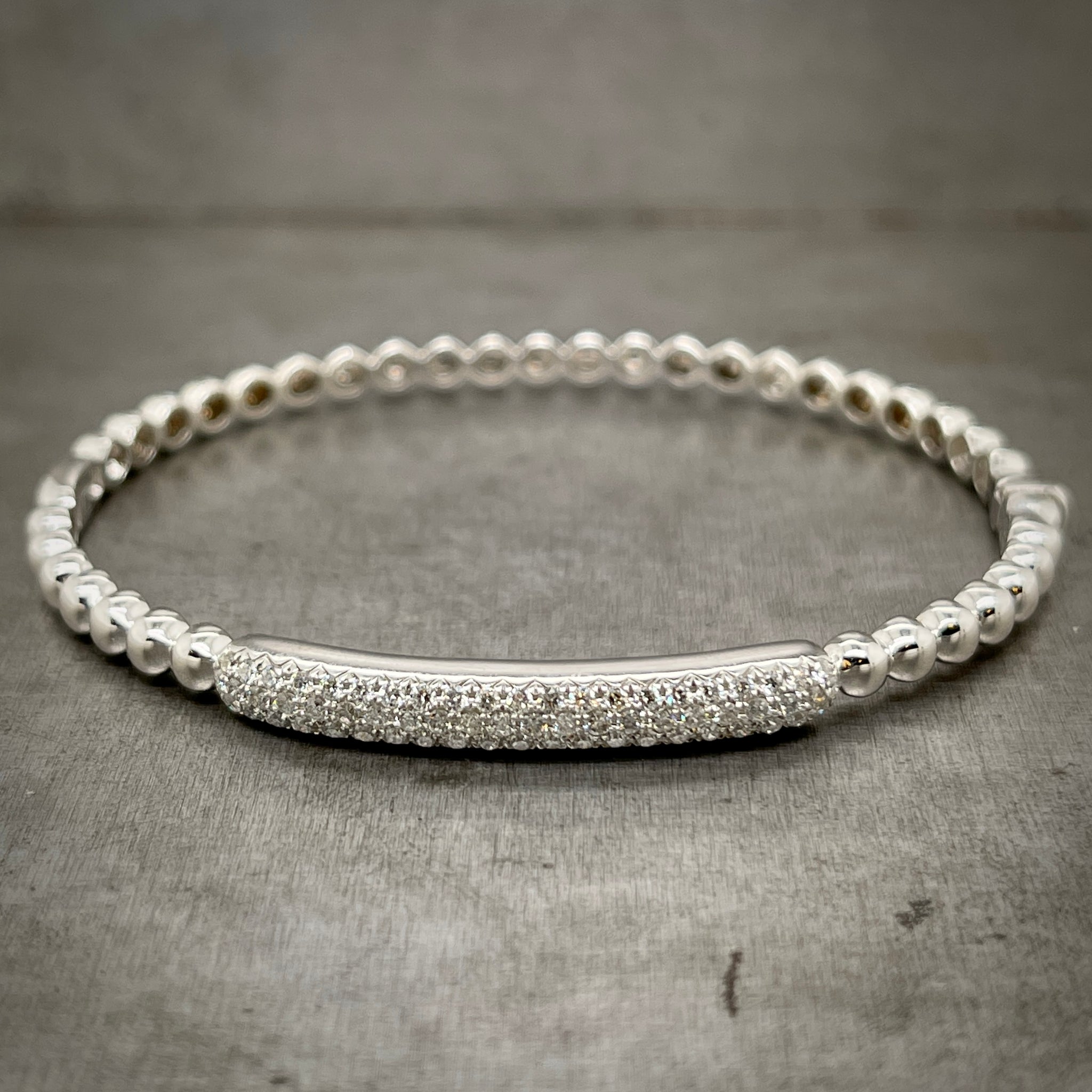 Full view of bangle laying down, here you can better see the portion/bar of diamonds. There are 3 rows of round diamonds in this bar.