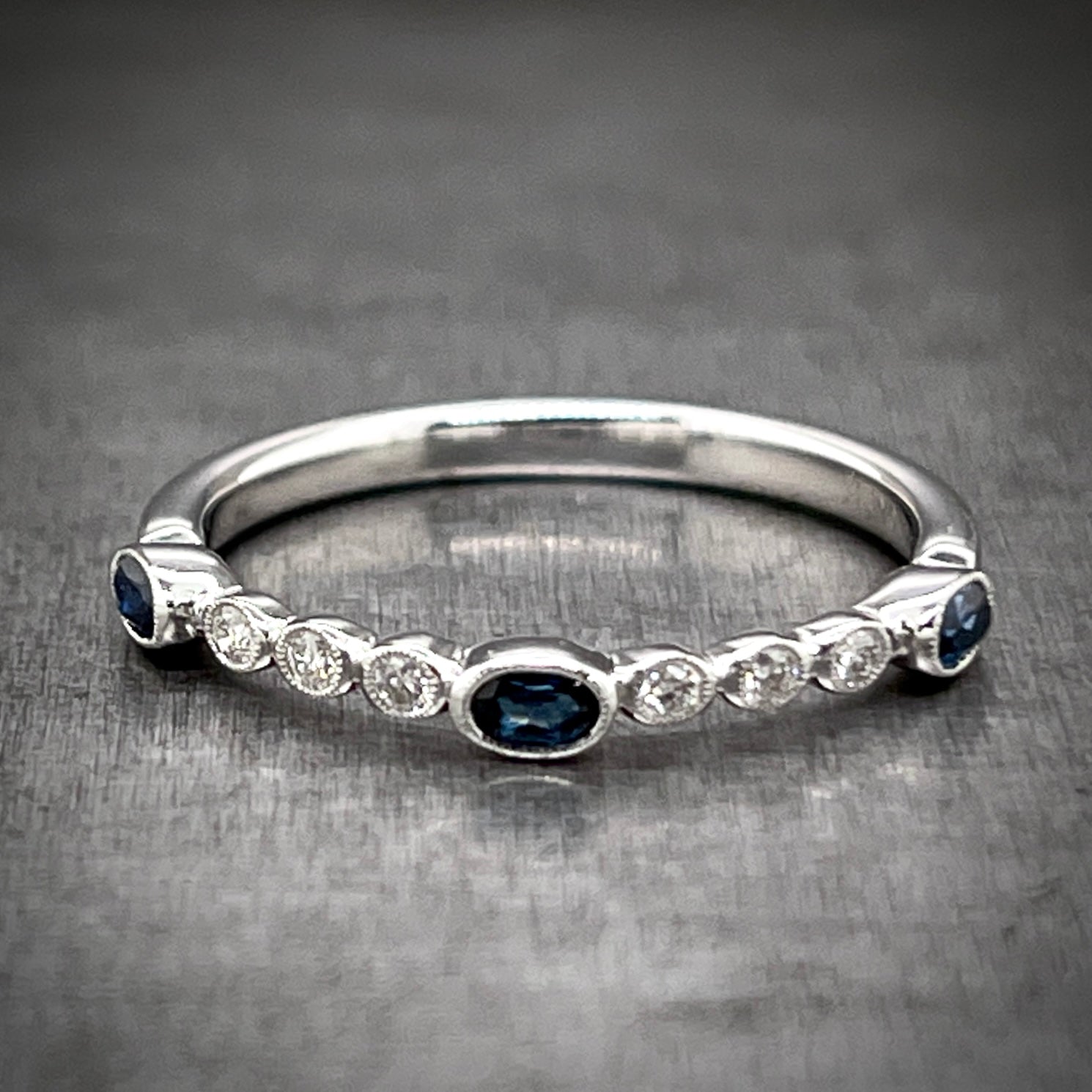 Full view of sapphire and diamond ring laying down.