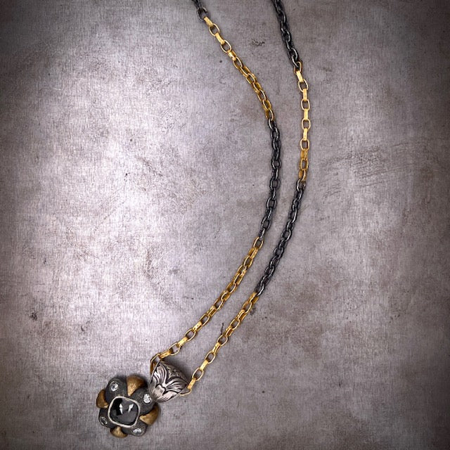 Full view of Black Diamond Gothic Pendant. Pendant is in bottom left corner and the chain snakes through the image. Here you can see the curb chain is multicolored with portions of gold and then equal portions of oxidized sterling silver.
