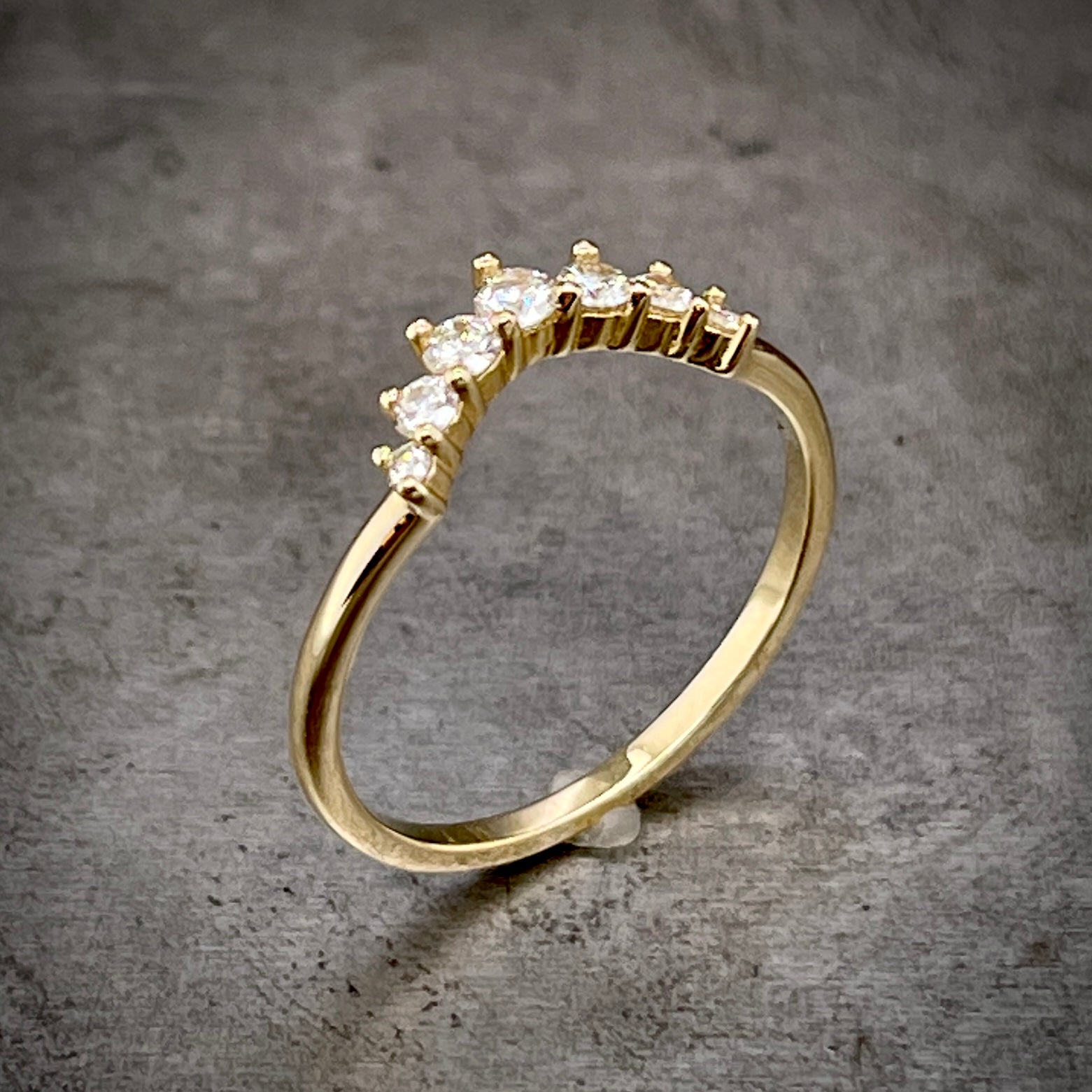 Angled aerial view of diamond tiara ring. Here you can see the diamonds are each three prong set.