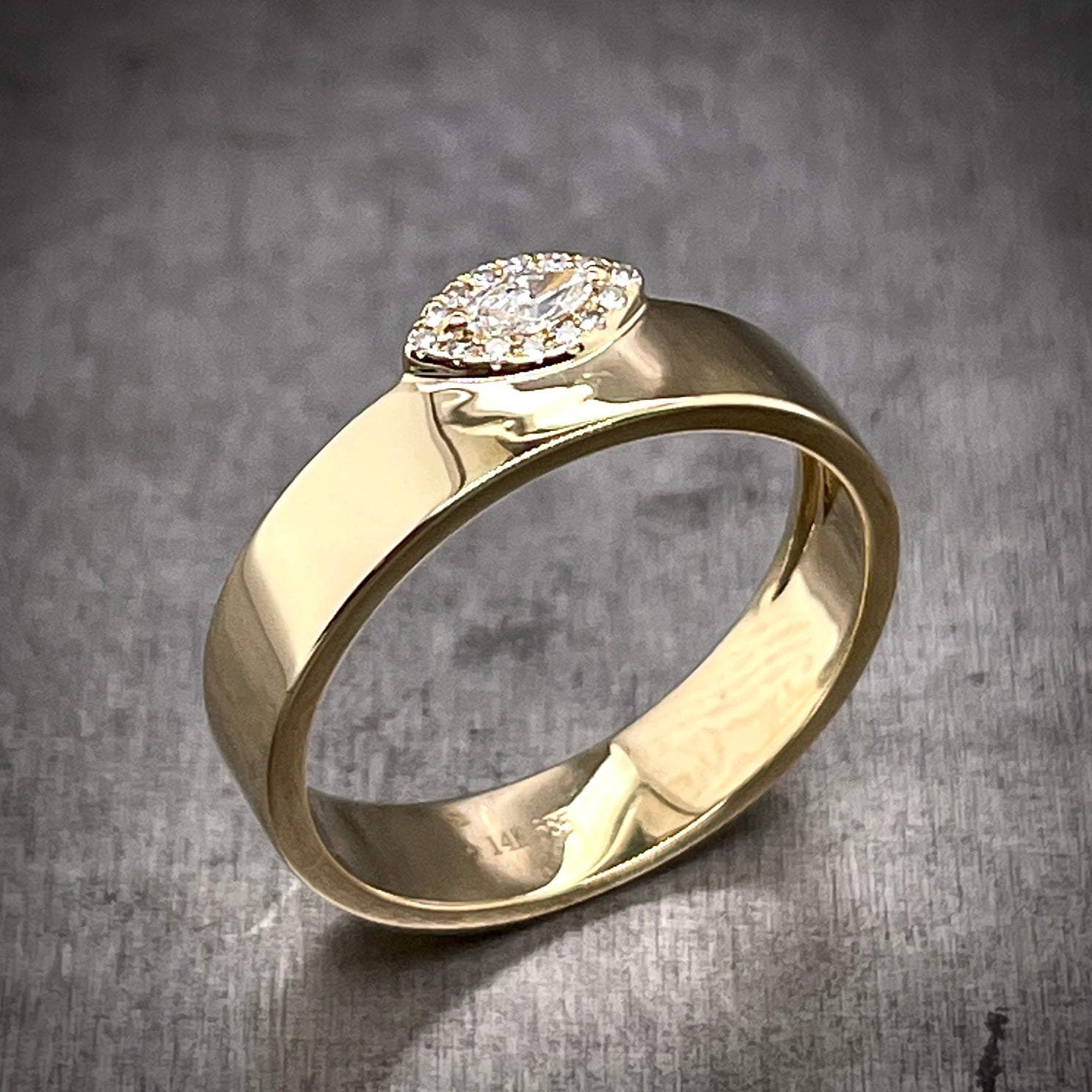 Angled aerial view of marquise evil eye ring. The evil eye hangs slightly off the edge of the band with the top half exposed.