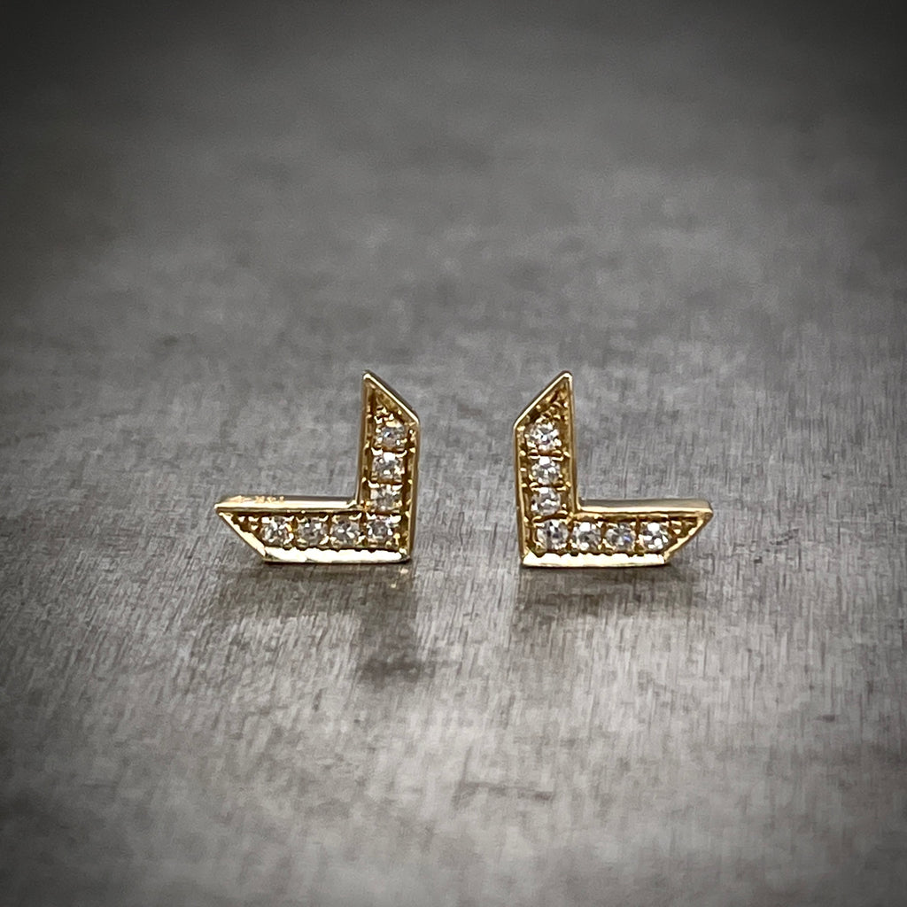 Full view of Gold and Diamond Arrow Earrings. These earrings feature one row of round brilliant diamonds on its surface and create the shape of a "V".