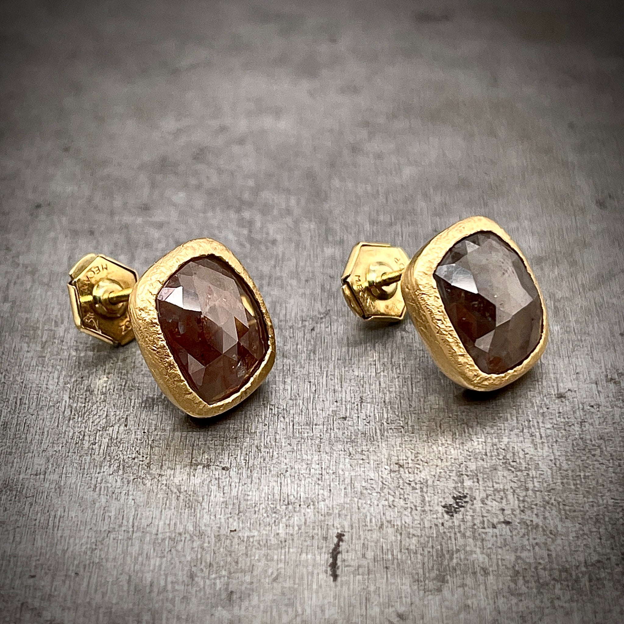 Partial Sideview of Rose Cut Red/Brown Diamond Earrings. Earrings Feature 18K Yellow Gold Bezels