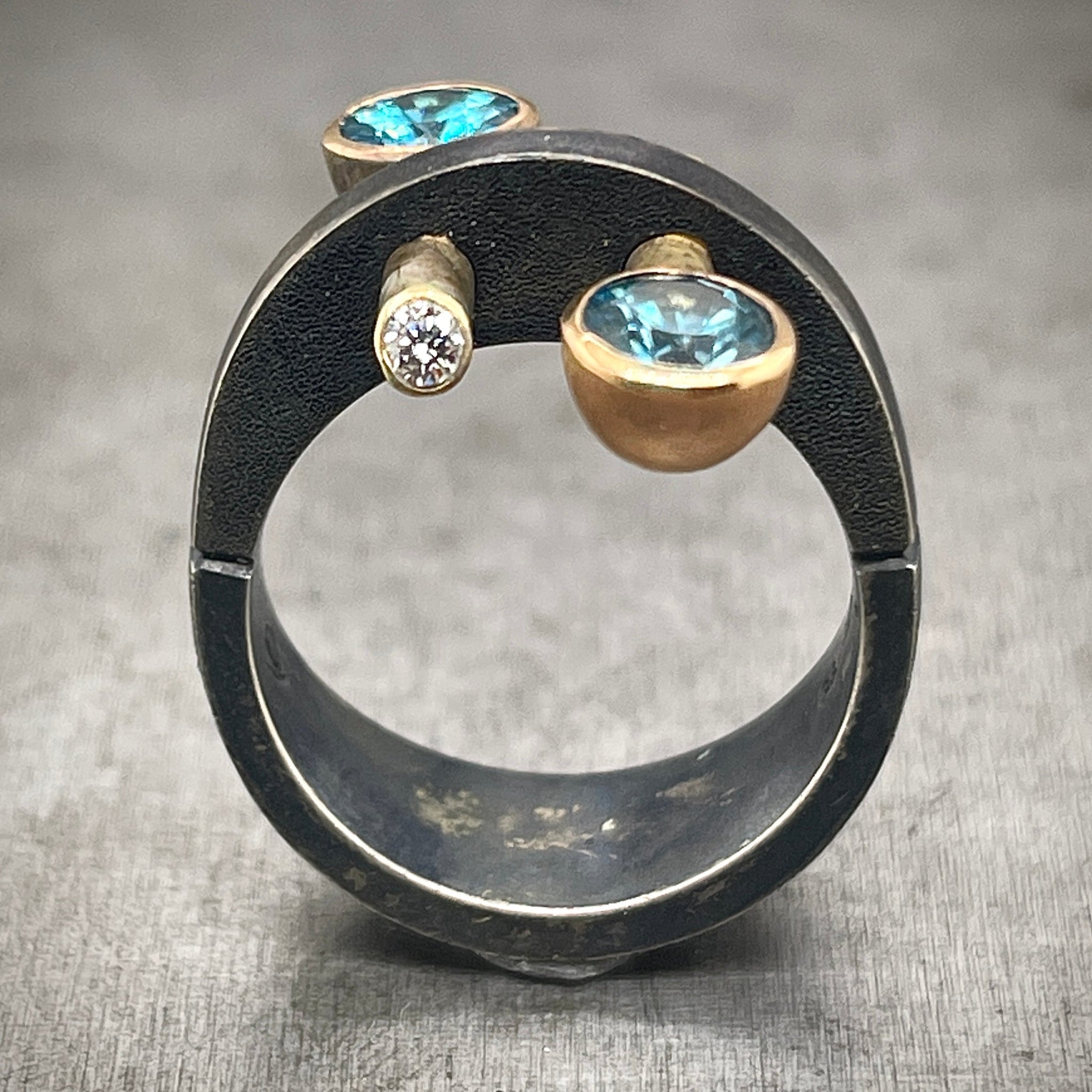 Oxidized Sterling Silver and Gold Ring, with Blue Zircons and Diamonds.. This image is a frontal view. 