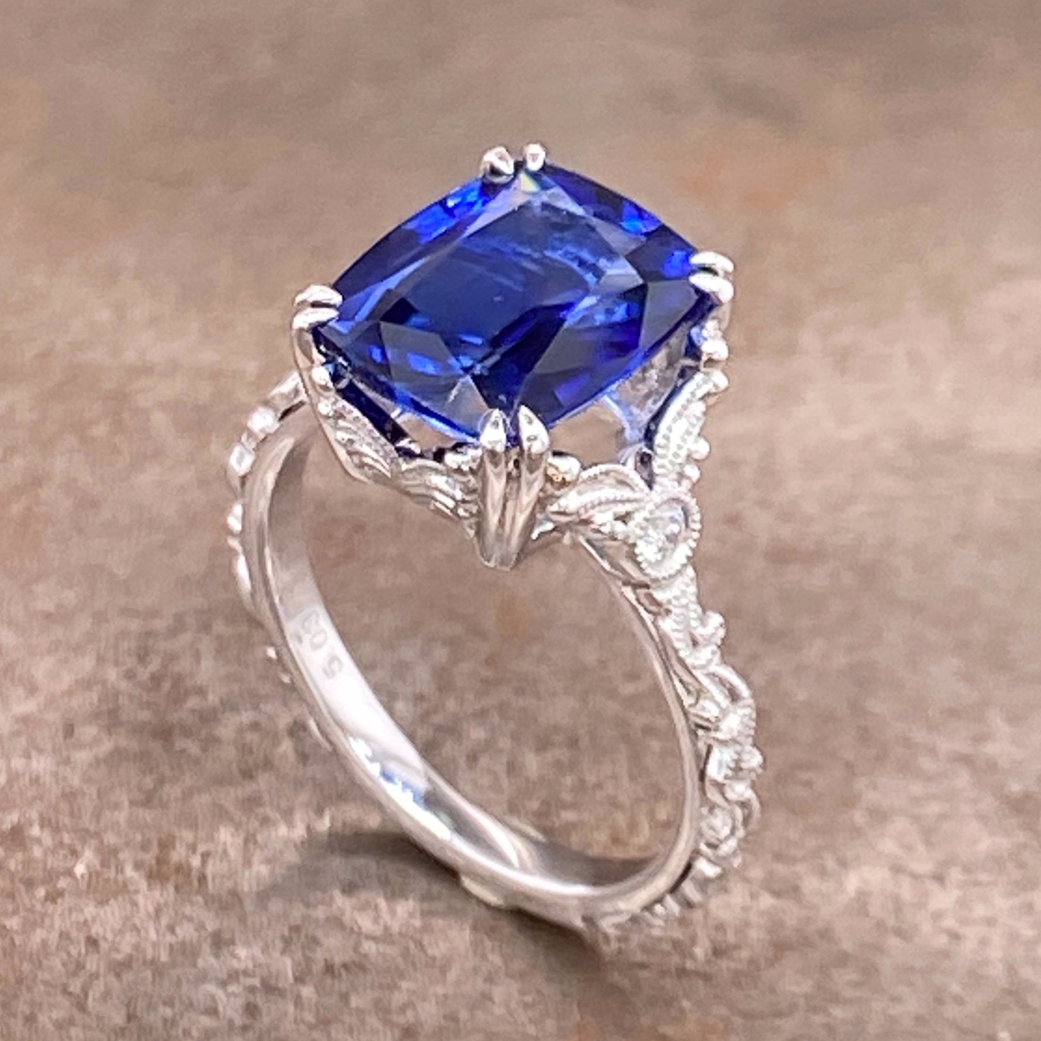 Opposite aerial angled view of sapphire and 14 karat white gold ring.