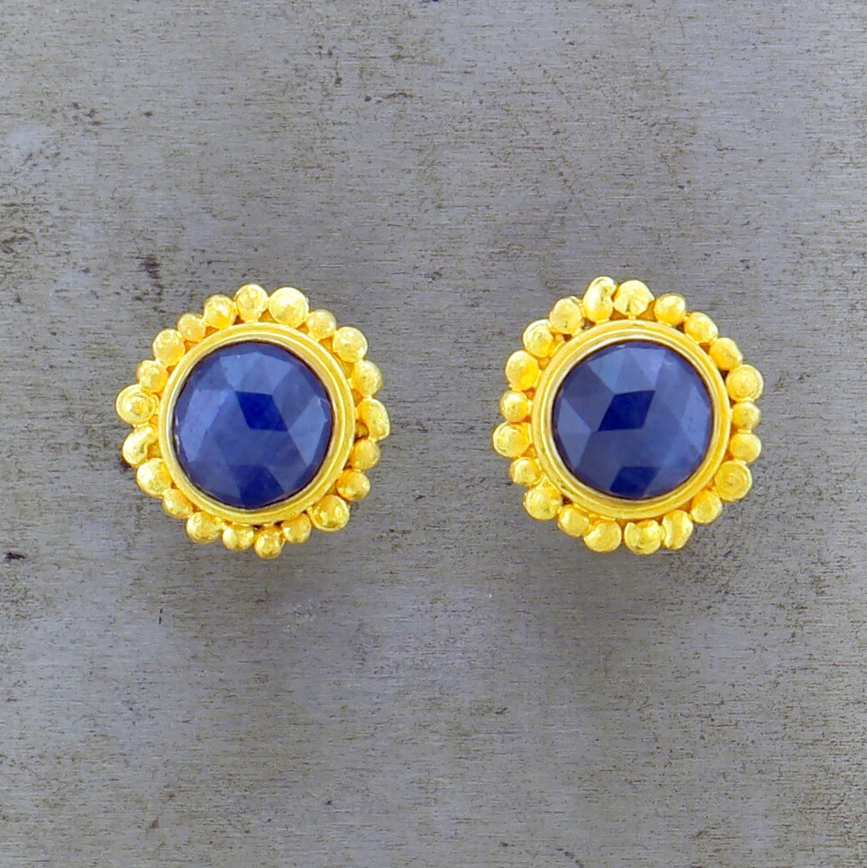 Frontal view of 22 karat yellow gold blue corundum post earrings.
