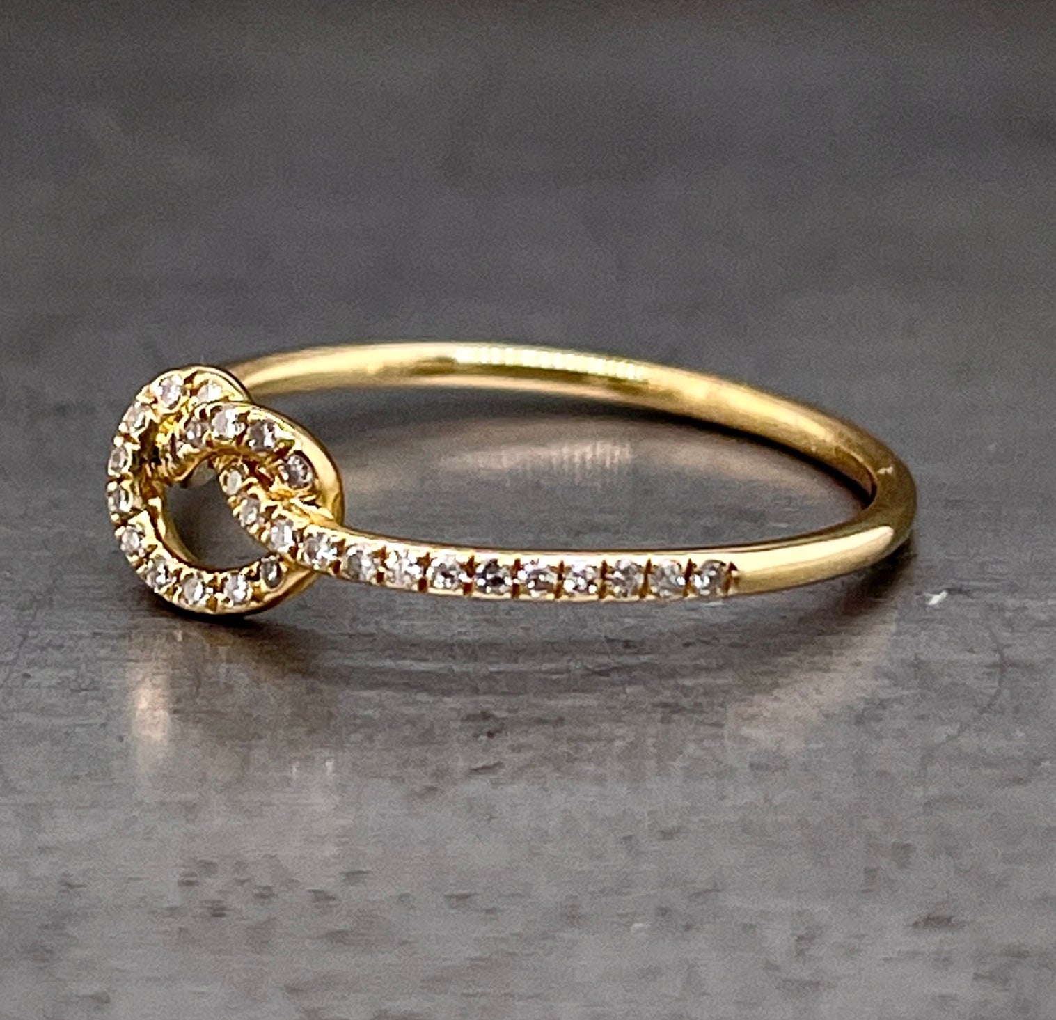 Side view of love me knot ring. here you can see the layer of round brilliant diamonds only travels to the shoulders of the ring, they stop at the shank and then it is only gold.