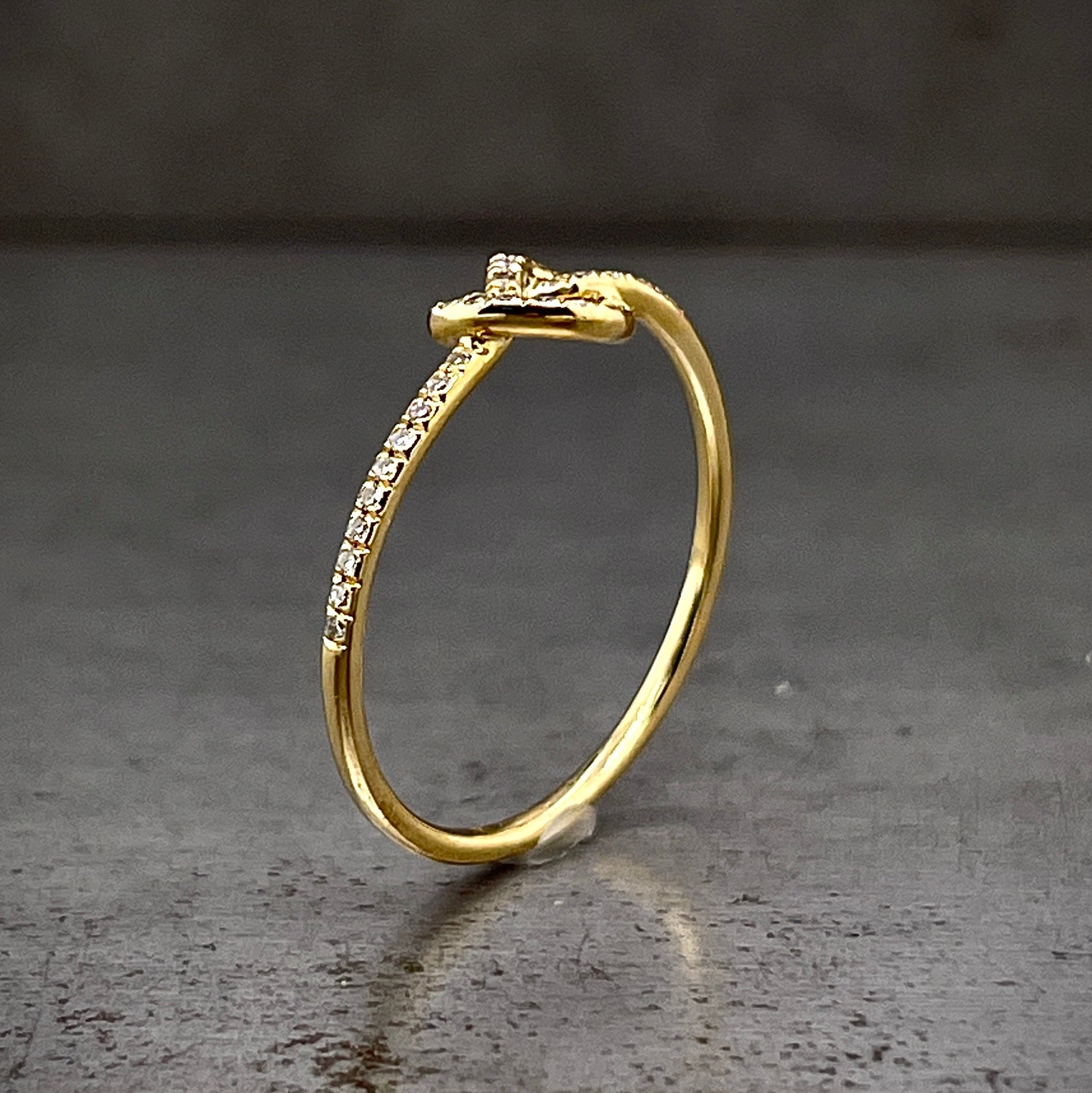 Angled side view of love me knot ring standing up.