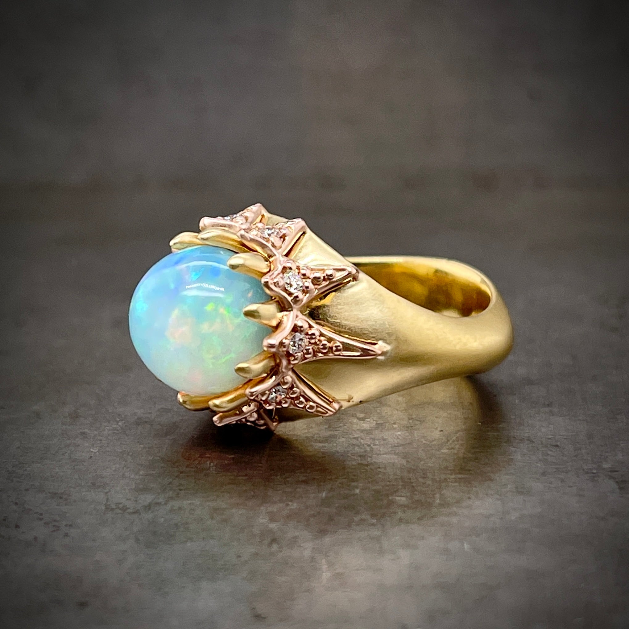 3/4 profile of opal and diamond gold ring.