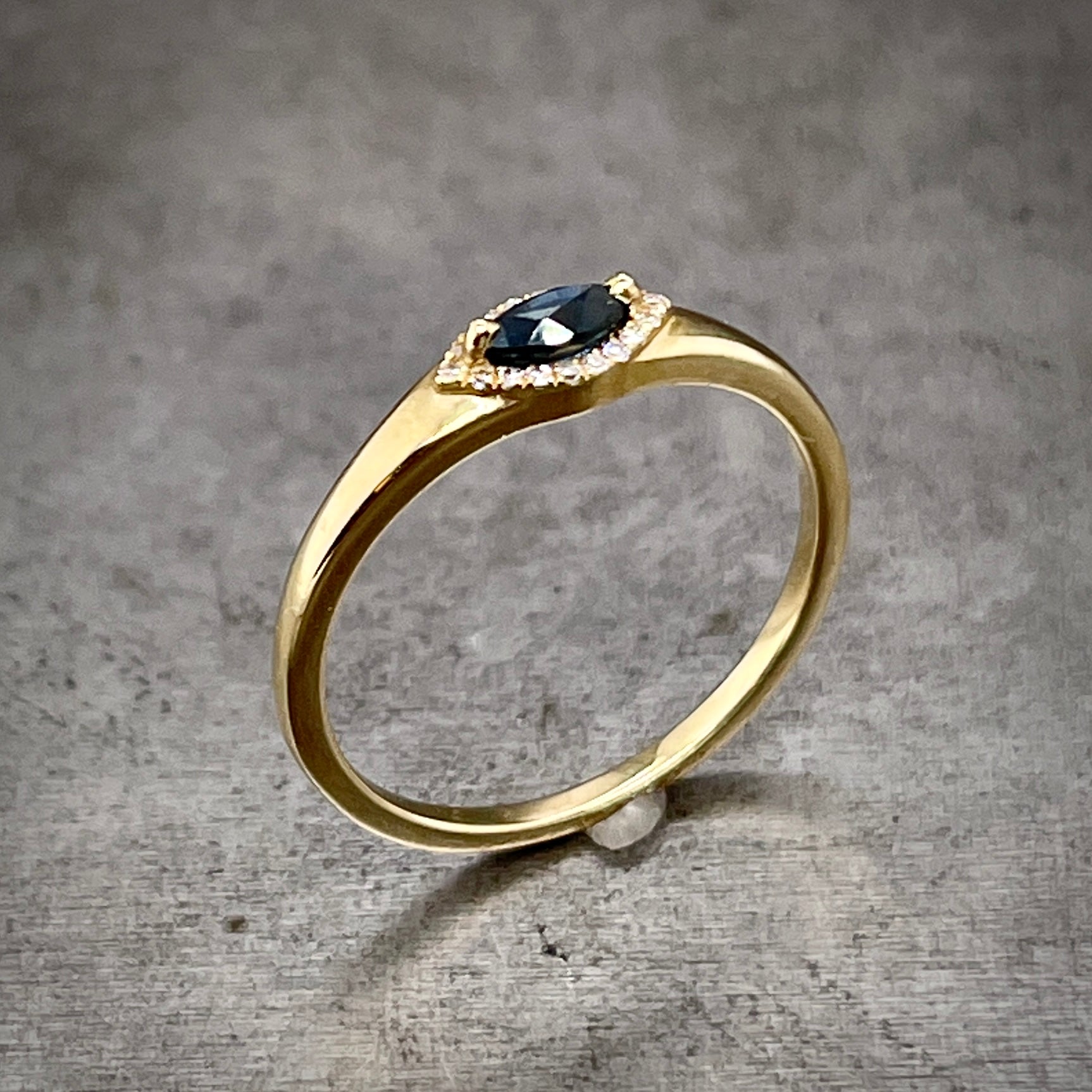 Angled aerial view of marquise sapphire ring standing up.