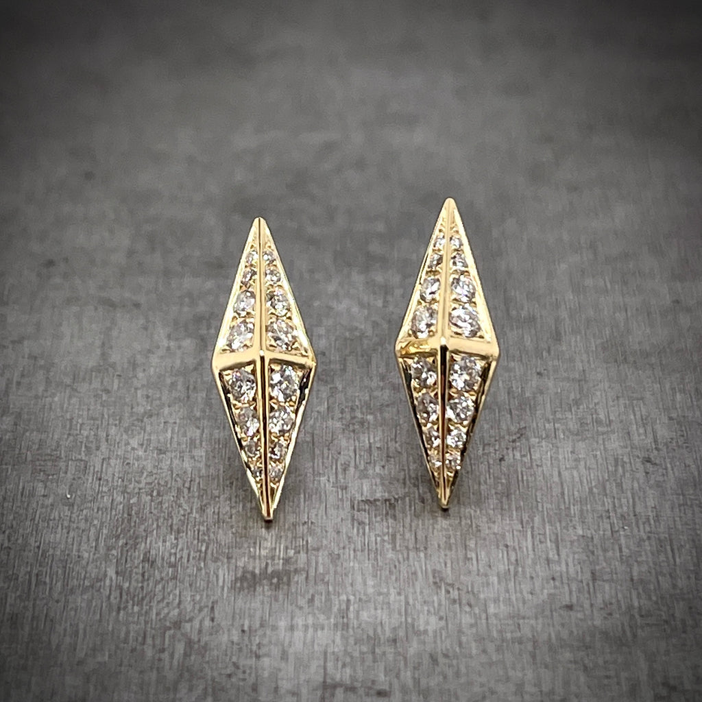 Full view of front of Gold and Diamond Kite Studs. They create the shape of a kite, or an elongated diamond, with a cross made through it out of gold. In each quadrant there are round brilliant diamonds pave set.