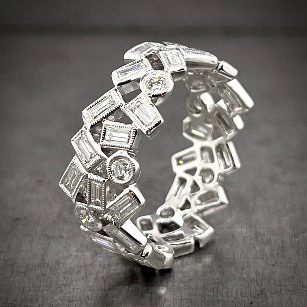 Aerial view of asymmetrical diamond band standing up. This band features rectangular and circle shaped diamonds on it band that are positioned every-which-way, creating most of the time 2 rows but sometimes 3 rows.