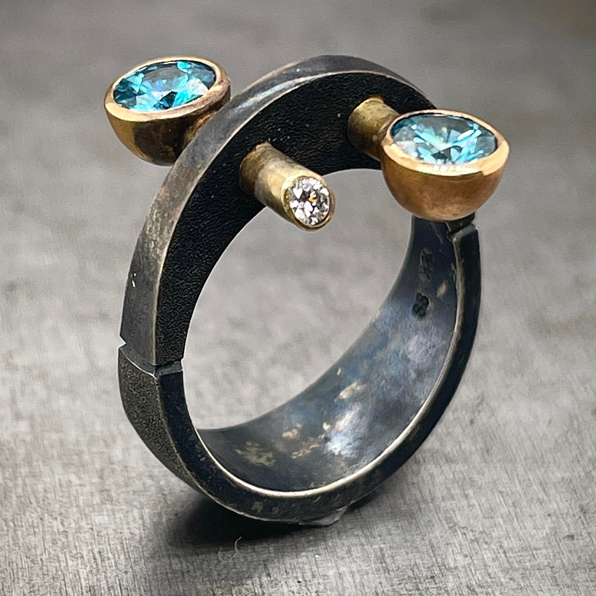 Oxidized Sterling Silver and Gold, Blue Zircon and Diamond Ring. The ring is upright, turned to display a 3/4 view. 