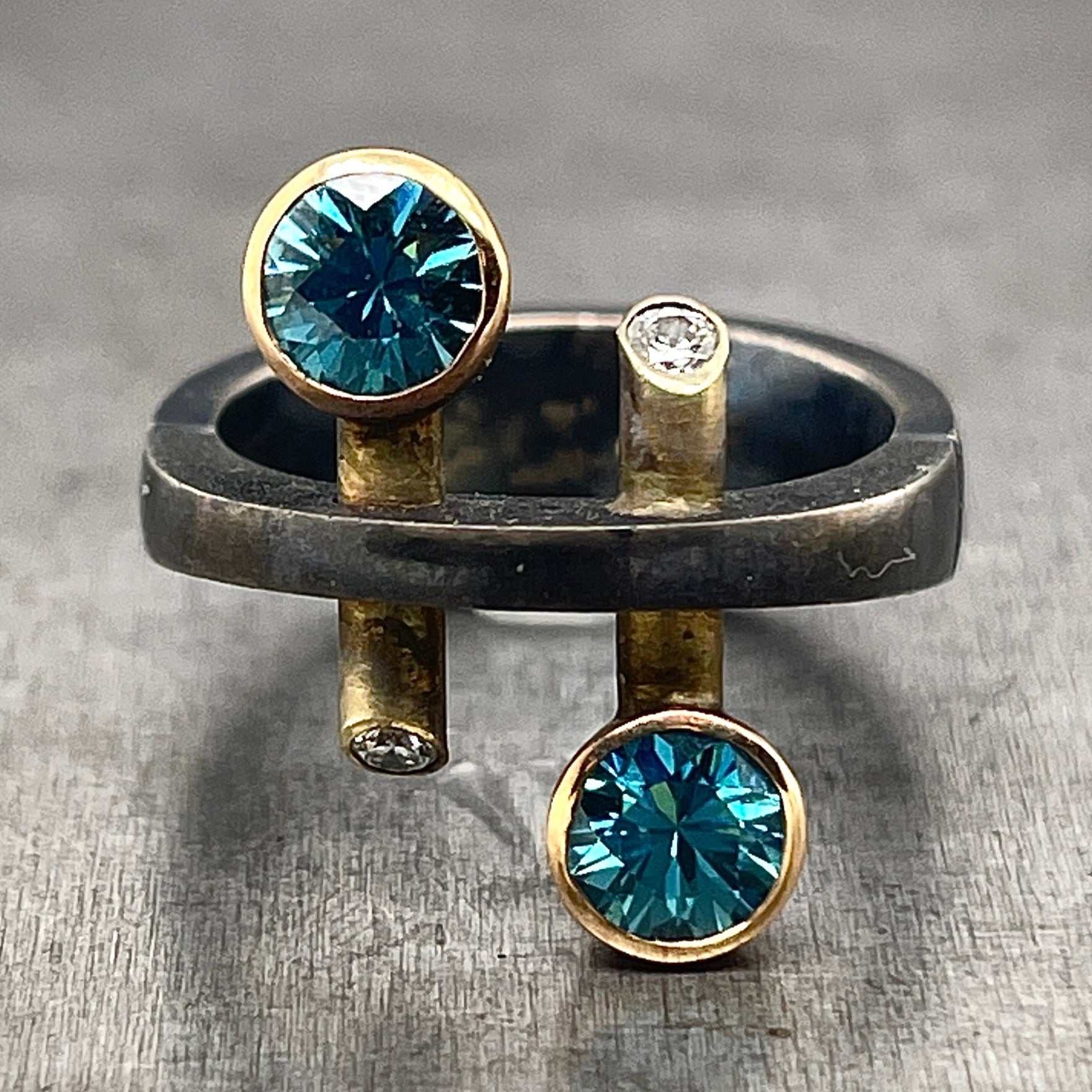 Blue Zircon and Diamond, Oxidized Sterling Silver and gold ring. This image is a front view of the top of the ring, showcasing the blue zircons.