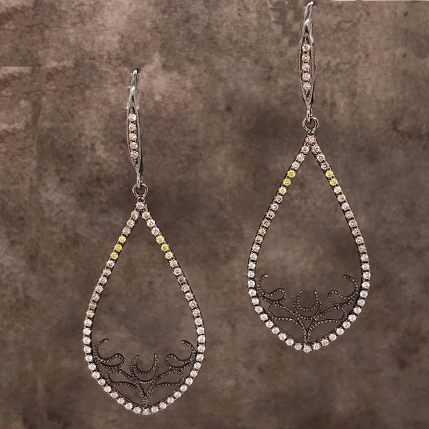 The top of these earrings features an oxidized sterling silver setting with five round brilliant diamonds channel set in it. Hanging from this is a teardrop like shape, but only the outline and features round diamonds with that have a yellow coloring. At the bottom is the outline of a deer and antlers made from oxidized sterling silver.